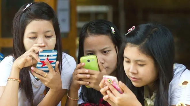 Young women staring at mobile phones
