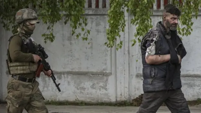 Self-proclaimed Donetsk People"s Republic (DPR) militia escorts an Ukrainian serviceman as he is being evacuated from the besieged Azovstal steel plant in Mariupol, Ukraine, 17 May 2022.