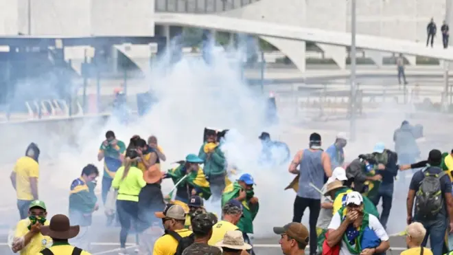 Policiais tentam dispersar bolsonaristas nos arredores do Congresso com gás lacrimogêneo.