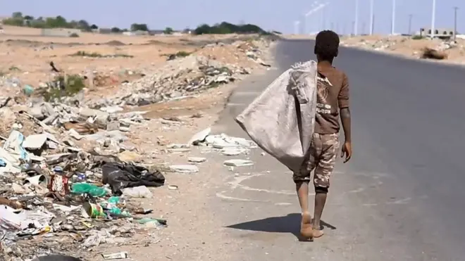 เด็กแบกถุงอยู่ข้างถนน