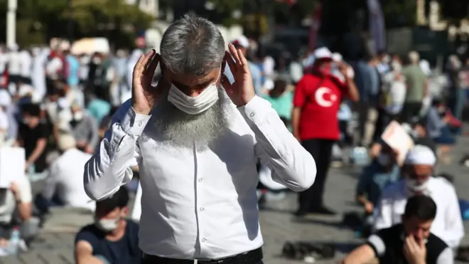 People wait for the first Friday prayer during the official opening ceremony of Hagia Sophia as a mosque in Istanbul