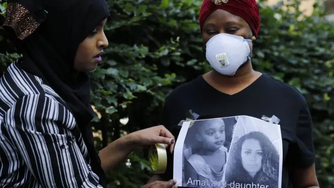 Dua perempuan memasang foto mereka yang hilang dalam kebakaran Grenfell Tower. Korban meninggal 17 orang dan 76 masih hilang.