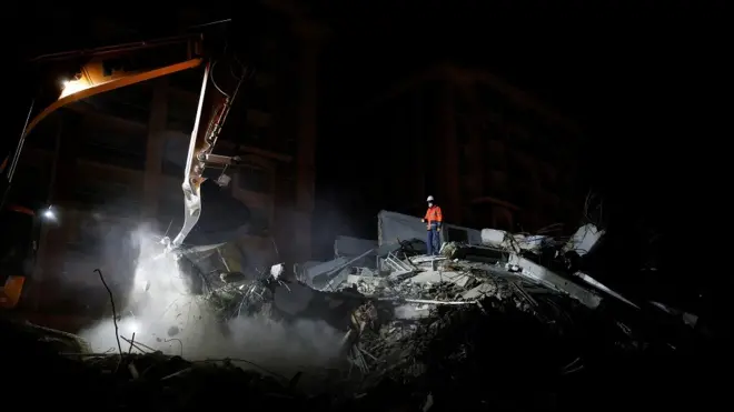 Rescuers work as they search for survivors in the aftermath of a deadly earthquake in Kirikhan, Turkey