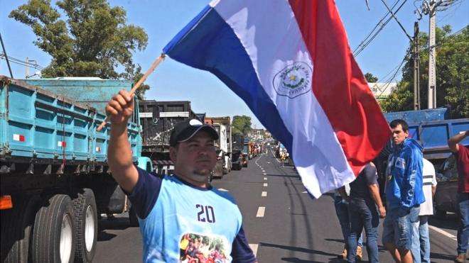 Manifestante con una bandera de Paraguay en una protesta. Foto de archivo.