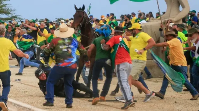 Un policía militar es agredido por militantes bolsonaristas tras caer de su caballo en la Plaza de los Tres Poderes.