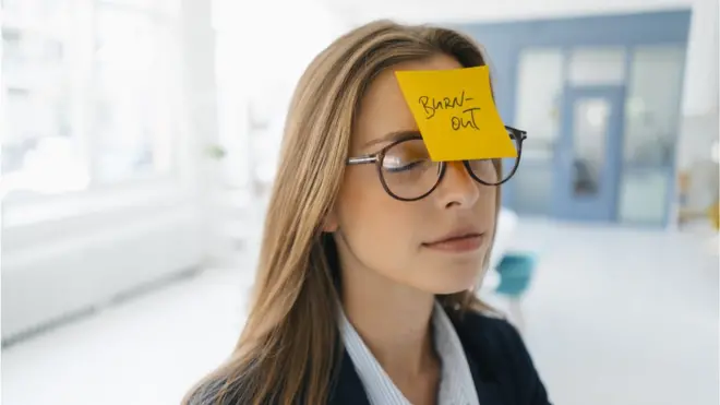 Jeune femme d'affaires avec une note autocollante jaune sur le front.