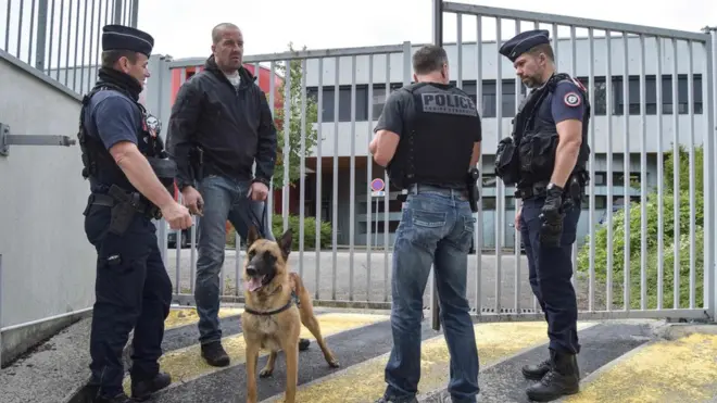 رجال الشرطة يفحصون أحد المشتبه بهم