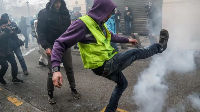 Yellow-vest protester kicks tear gas canister
