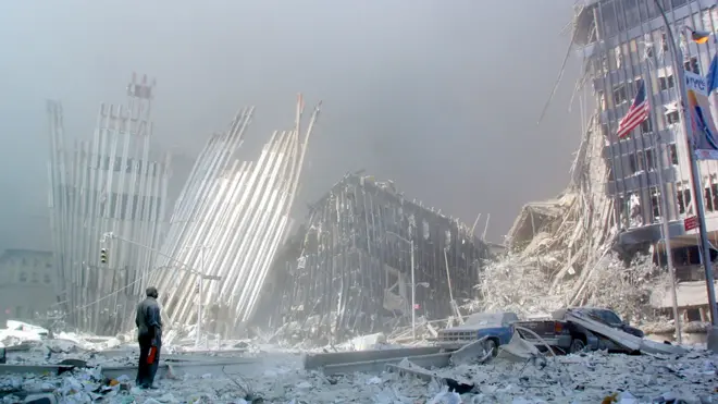 A man stands in the rubble, and calls out asking if anyone needs help, after the collapse of the first World Trade Center Tower 11 September, 2001, in New York.
