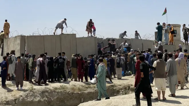 阿富汗首都喀布爾國際機場外的隔離牆外，民眾蜂擁而至，尋找機會出逃。