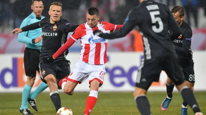 Игрок "Црвены звезды" Александар Пешич (в центре) и футболист ЦСКА Понтас Вернблум (слева) борются за мяч