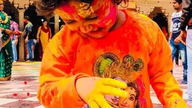 बरसाने के मंदिर में होली खेलती एक बच्ची