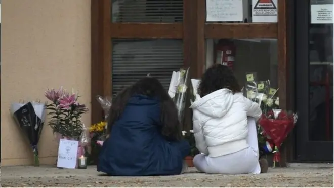 وُضعت باقات زهور أمام المدرسة التي كان يعمل فيها الضحية