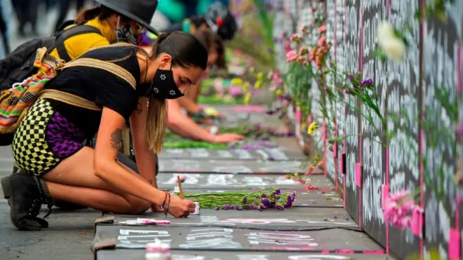 Grupos de mujeres han llegado al muro a escribir nombres de víctimas de feminicidio.