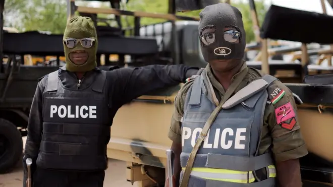 Two Nigerian policemen dey stand dey look