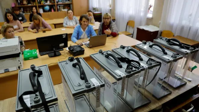 Members of the local electoral commission gather at a polling station ahead of the planned referendum on the joining of the self-proclaimed Donetsk people's republic to Russia