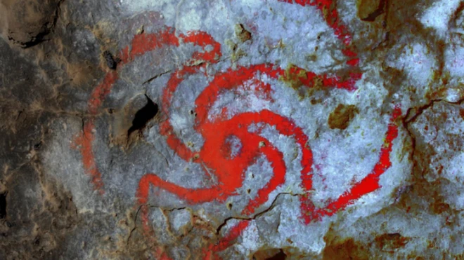 สัญลักษณ์บนเพดานใน "ถ้ำกังหัน" (Pinwheel Cave) ที่มีกากดอกลำโพงแปะติดอยู่