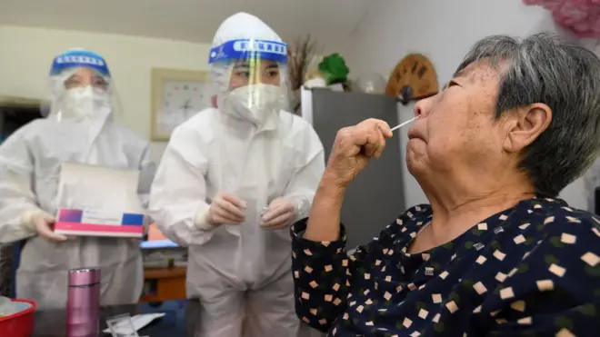 A staff member instructs elderly people on antigen testing at their home in Guiyang, Guizhou province, China, Sept 7, 2022.
