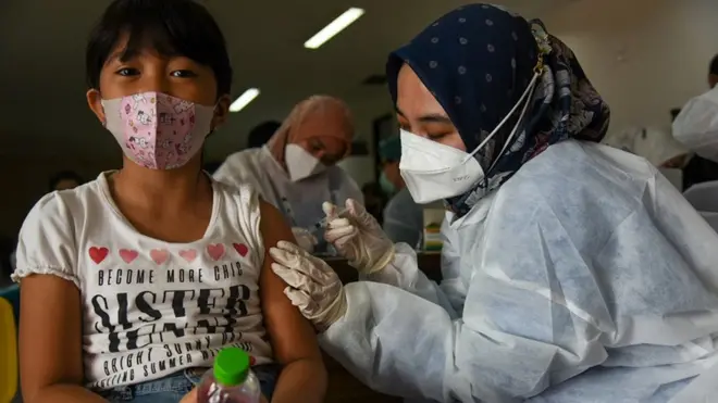 Petugas kesehatan menyuntikkan vaksin COVID-19 jenis Sinovac pada seorang anak saat vaksinasi massal anak usia 6-11 tahun di Rumah Sakit Universitas Sumatera Utara (USU), Kota Medan, Sumatera Utara, Kamis (30/12/2021).