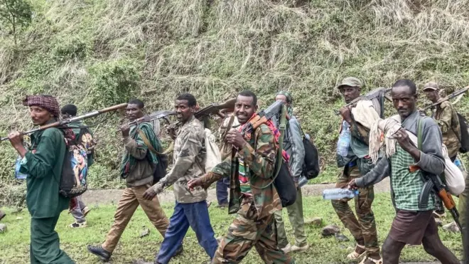 Members of the Amhara militia walk along the road in a rural area near the village of Adi Arkay, 180 kilometers northeast from the city of Gondar, Ethiopia, on July 14, 2021