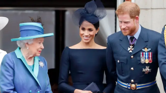 Queen Elizabeth II, Meghan, Duchess of Sussex and Prince Harry, Duke of Sussex watch a flypast to mark the centenary of the Royal Air Force from the balcony of Buckingham Palace on July 10, 2018