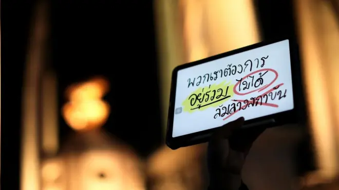 ผู้ชุมนุมชูไอแพดที่เขียนข้อความแสดงความเห็น