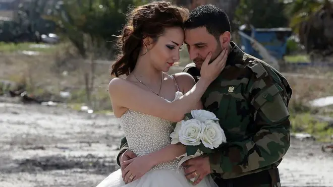 Pasangan yang baru menikah, Nada Merhi,18 tahun, dan suaminya yang berlatar tentara, Hassan Youssef, 27 tahun, bergaya untuk sebuah pemotretan di Kota Homs, Suriah, 5 Februari 2016