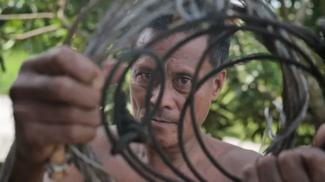 Mawi mengenggam jerat dari sling baja yang digunakan untuk membunuh ratusan harimau Sumatra.