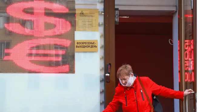 женщина выходит из обменника