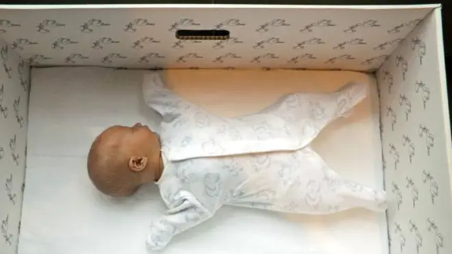 Un bebé duerme en una caja de cartón