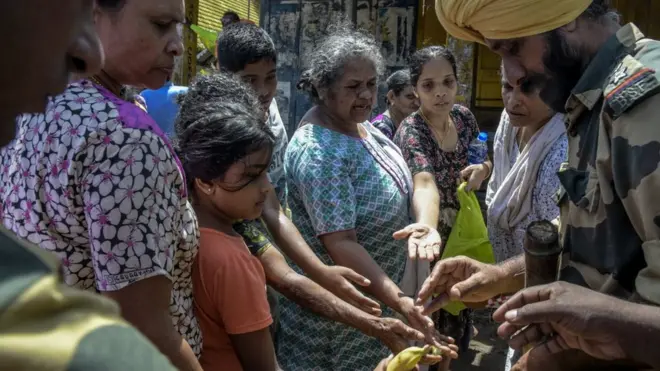 Women receiving food from the military