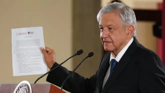 AMLO firmando el documento.