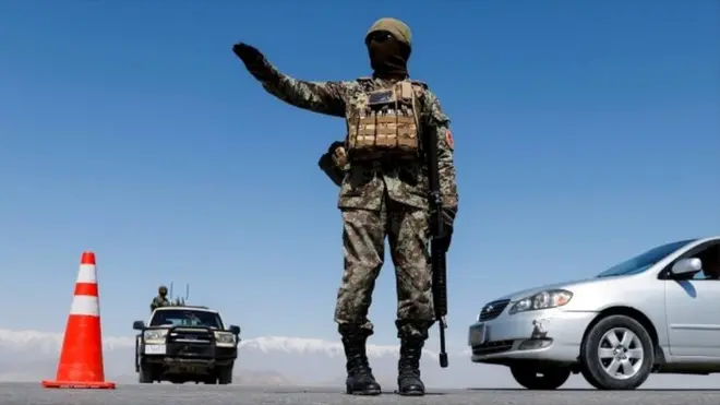 An Afghan National Army soldier stands guard at a checkpoint near Kabul in April 2021