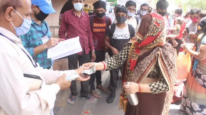 અમદાવાદમાં કલેકટર કચેરીના અધિકારીને ટિકિટના પૈસા ચૂકવી રહેલાં એક શ્રમિક મહિલા