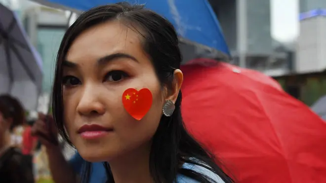 香港添马公园亲政府集会上一名女示威者在脸颊贴上中国国旗（17/8/2019）