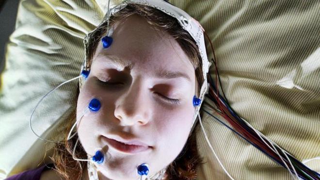 Mujer durmiendo con electrodos