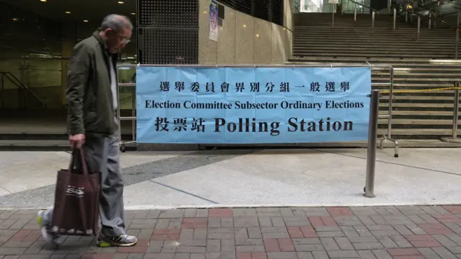 一名老伯在香港中環一處投票站外走過(BBC中文網圖片11/12/2016)