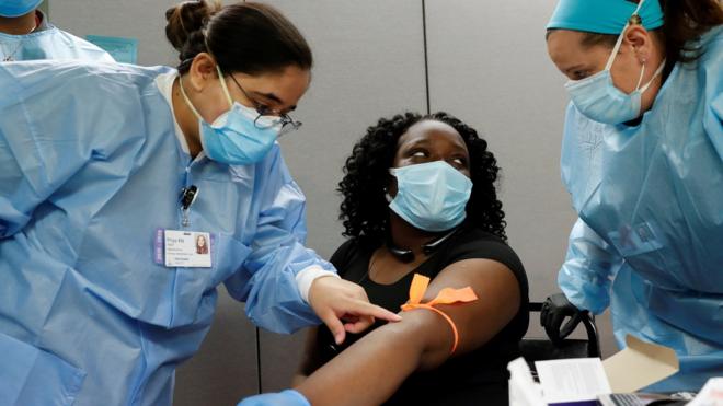 紐約一家醫院內身穿個人保護裝備的醫護人員給一名女士抽血檢測新冠病毒抗體（13/5/2020）