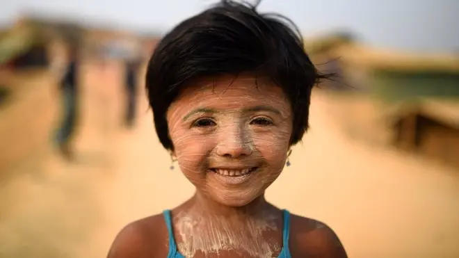 Rohingya refugee Nur Kayas, aged 6, poses for a photograph as she wears thanaka paste at Kutupalong camp in Cox's Bazaar, Bangladesh