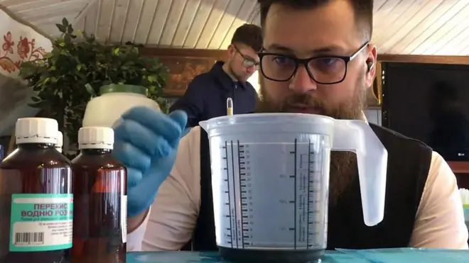 Sveštenik meri odnos sastojaka za antiseptik