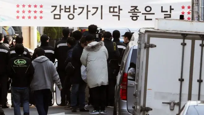 22일 이 전 대통령의 서울 논현동 사저 근처에서 시민들이 현수막을 들고 있다