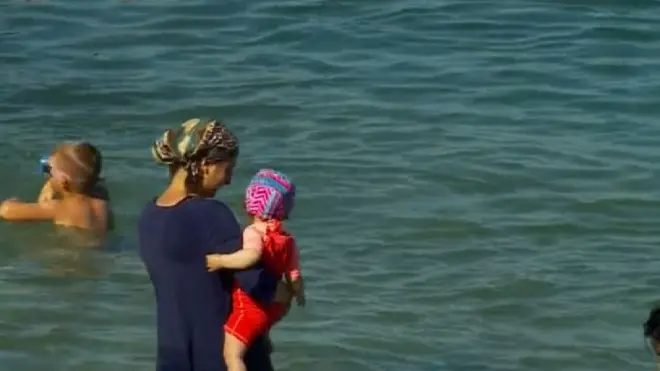 Женщина в буркини на пляже