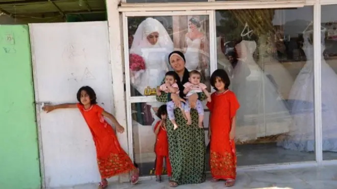 Rozhin Ahmed-Hussein berfoto bersama kelima putrinya di depan salon kecantikan miliknya.