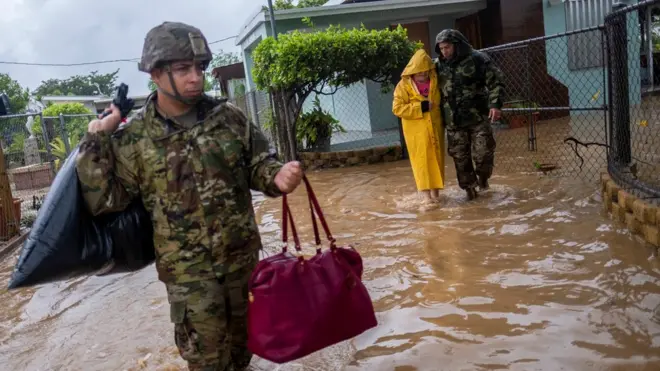 Imagen de dos soldados mientras socorren a una persona en Puerto Rico.