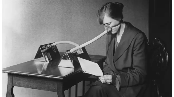 Seorang perempuan mengenakan masker flu selama pandemi flu Spanyol.