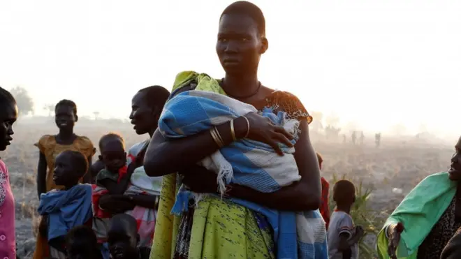 أم تحمل رضيعها من جنوب السودان