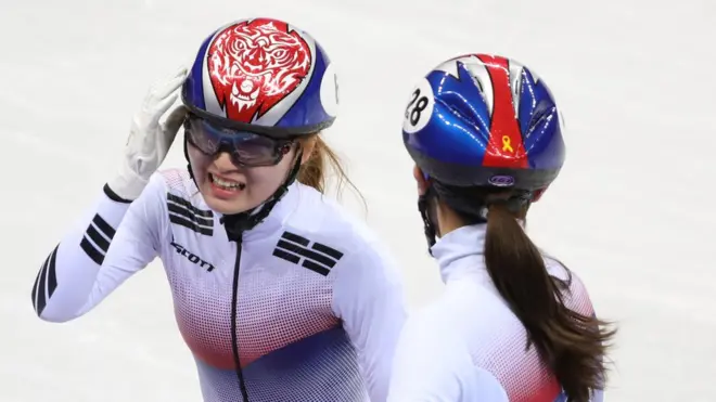 최민정을 격려하는 김아랑. 헬멧에 노란리본이 그려져있다.