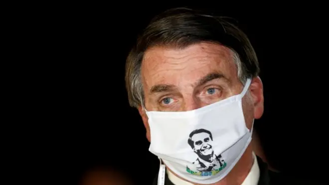 President Jair Bolsonaro speaks with journalists while wearing a protective face mask as he arrives at Alvorada Palace, amid the coronavirus disease (COVID-19) outbreak, in Brasilia, Brazil, May 22, 2020
