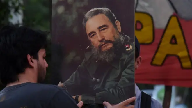 Seorang pendukung partai Komunis di Paraguay, memegang foto Fidel Castro sebagai tanda berkabung.