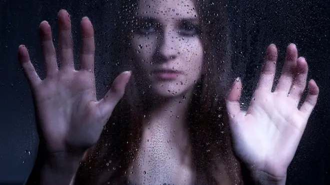 Женщина за стеклом с каплями